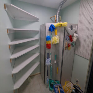 Laundry Room Renovation photo 6: Building the pantry behind the new wall with shelving for food products and pegboards for hanging supplies.